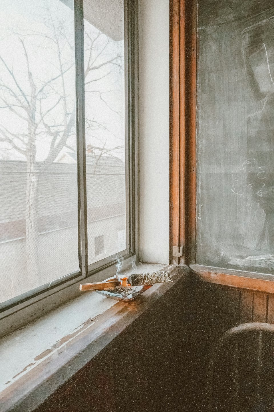 Burning sage and palo santo on a windowsill with smoke.